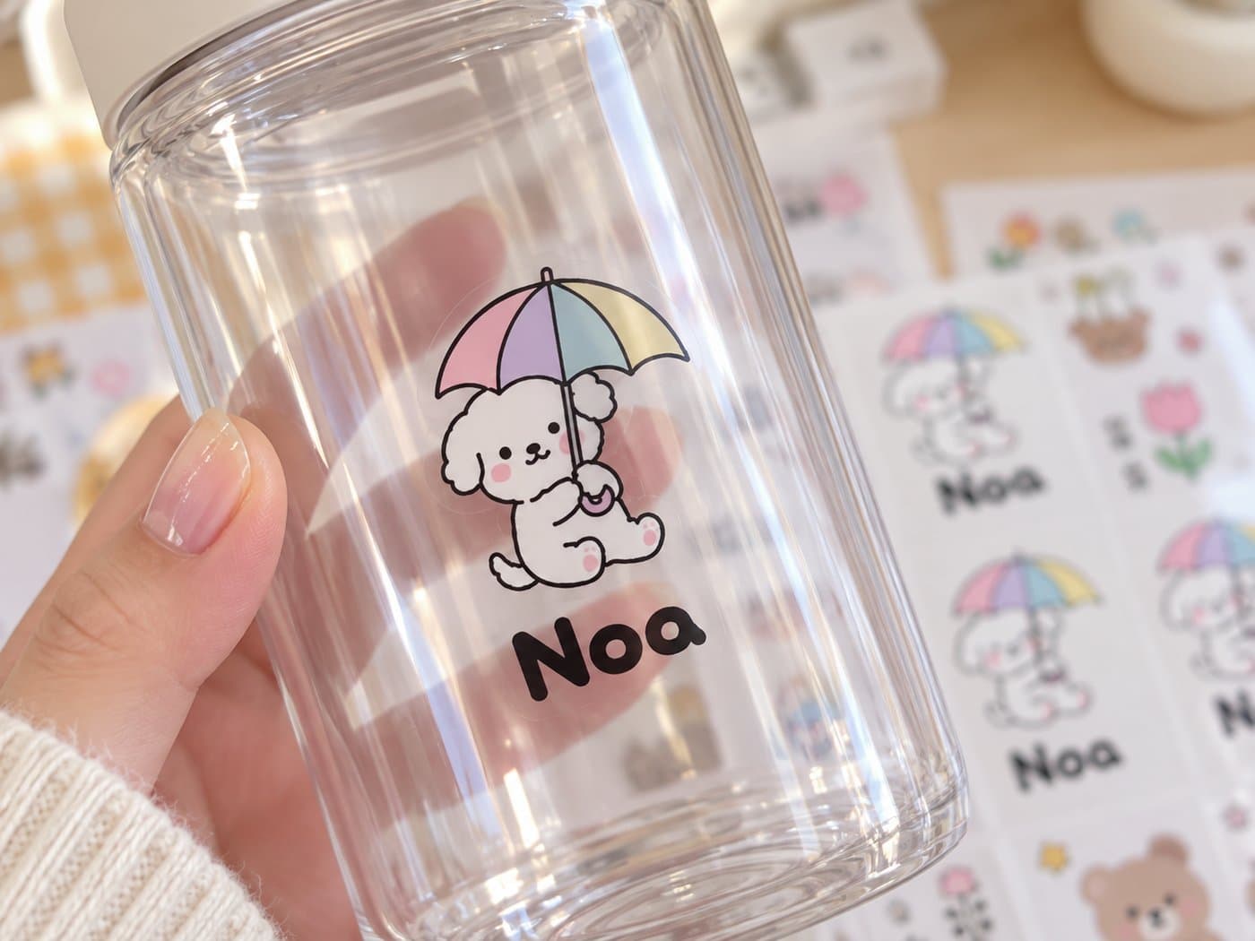 Personalized waterproof name labels and character stickers applied to a water bottle, lunch box, and school supplies